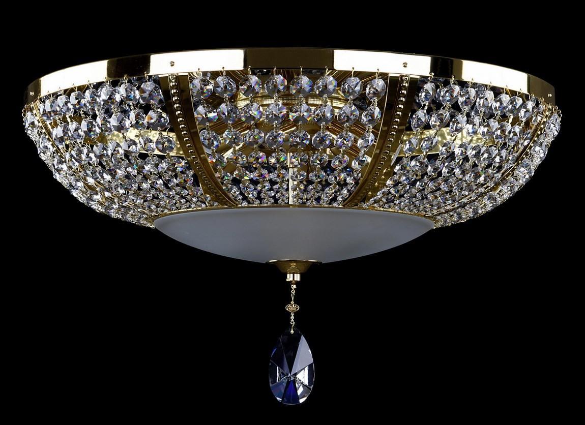 Plafonnier doré vu de face sur fond noir, cristaux et goutte bleue