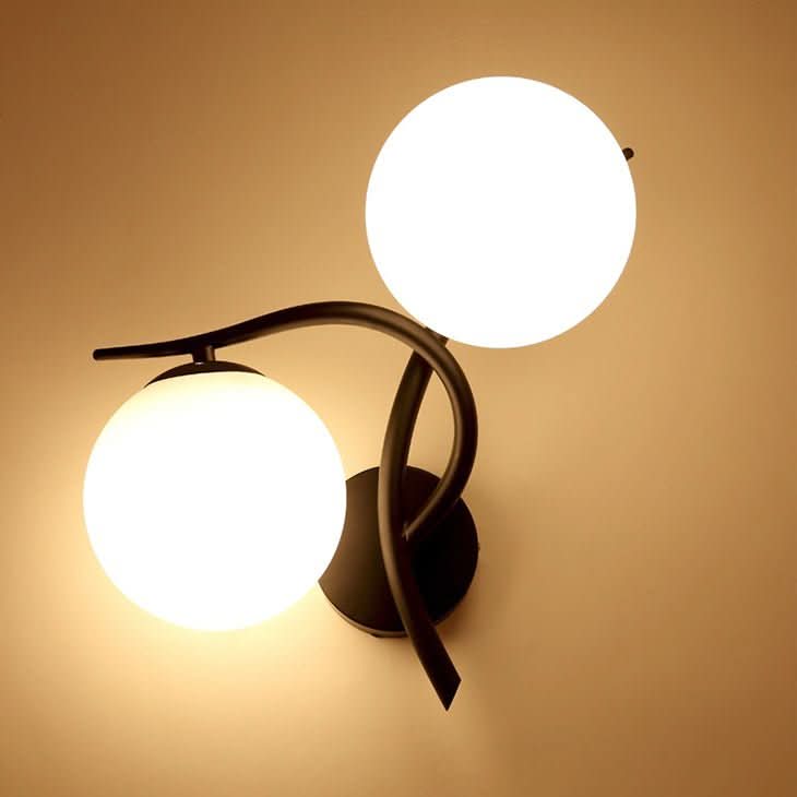 Applique murale allumée à deux globes de verre blanc et bras noirs courbés