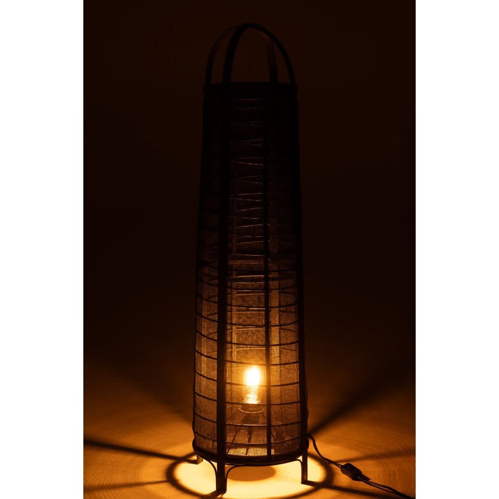 Lampe allumée dans le noir, ampoule visible, halo chaud à travers le tissu.