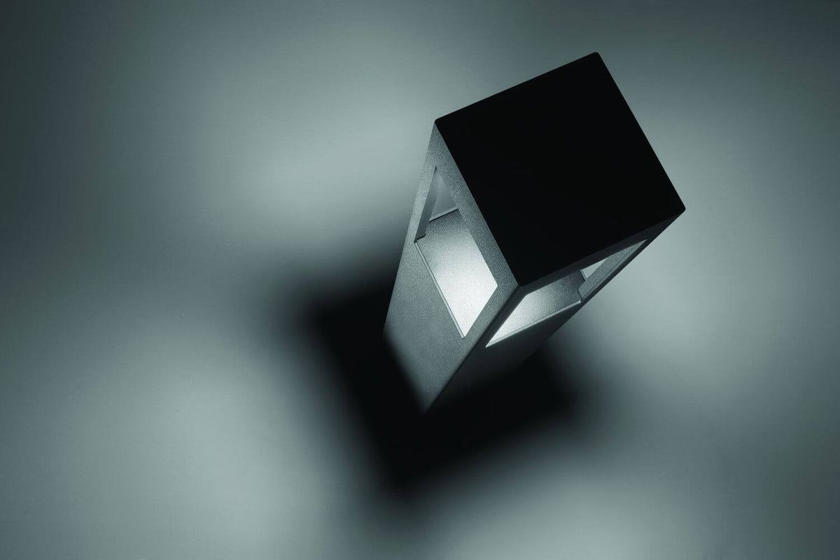 Vue en plongée du luminaire éclairé, ombre portée sur surface grise