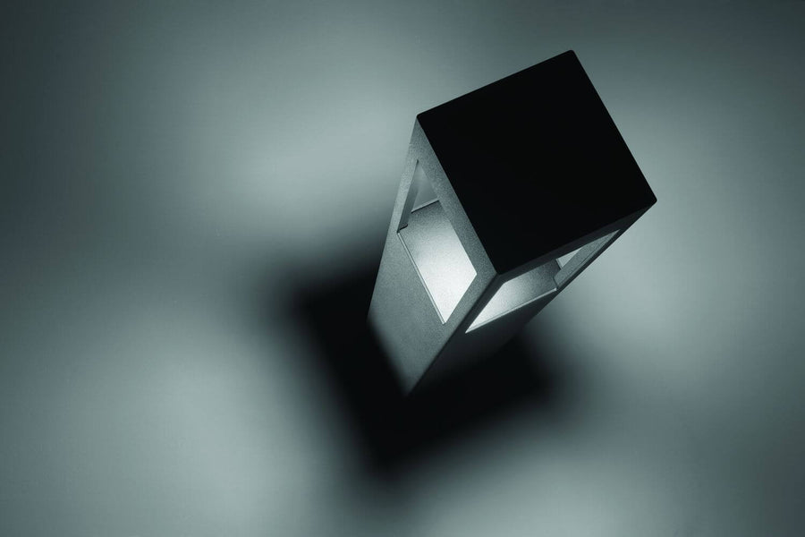 Vue en plongée du luminaire éclairé, ombre portée sur surface grise