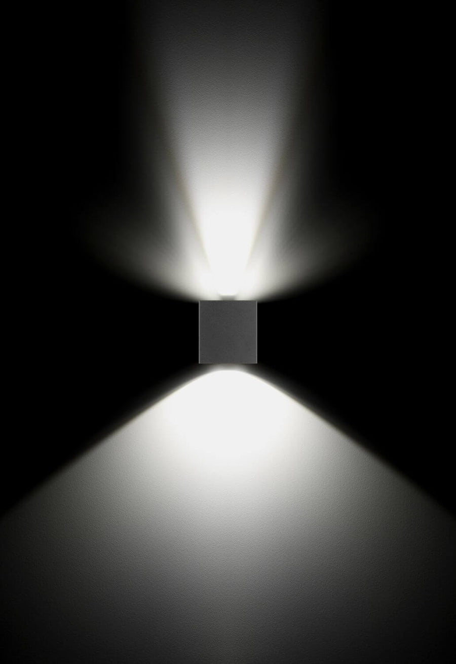 Effet de lumière sur fond noir : double faisceau haut et bas d'une applique murale