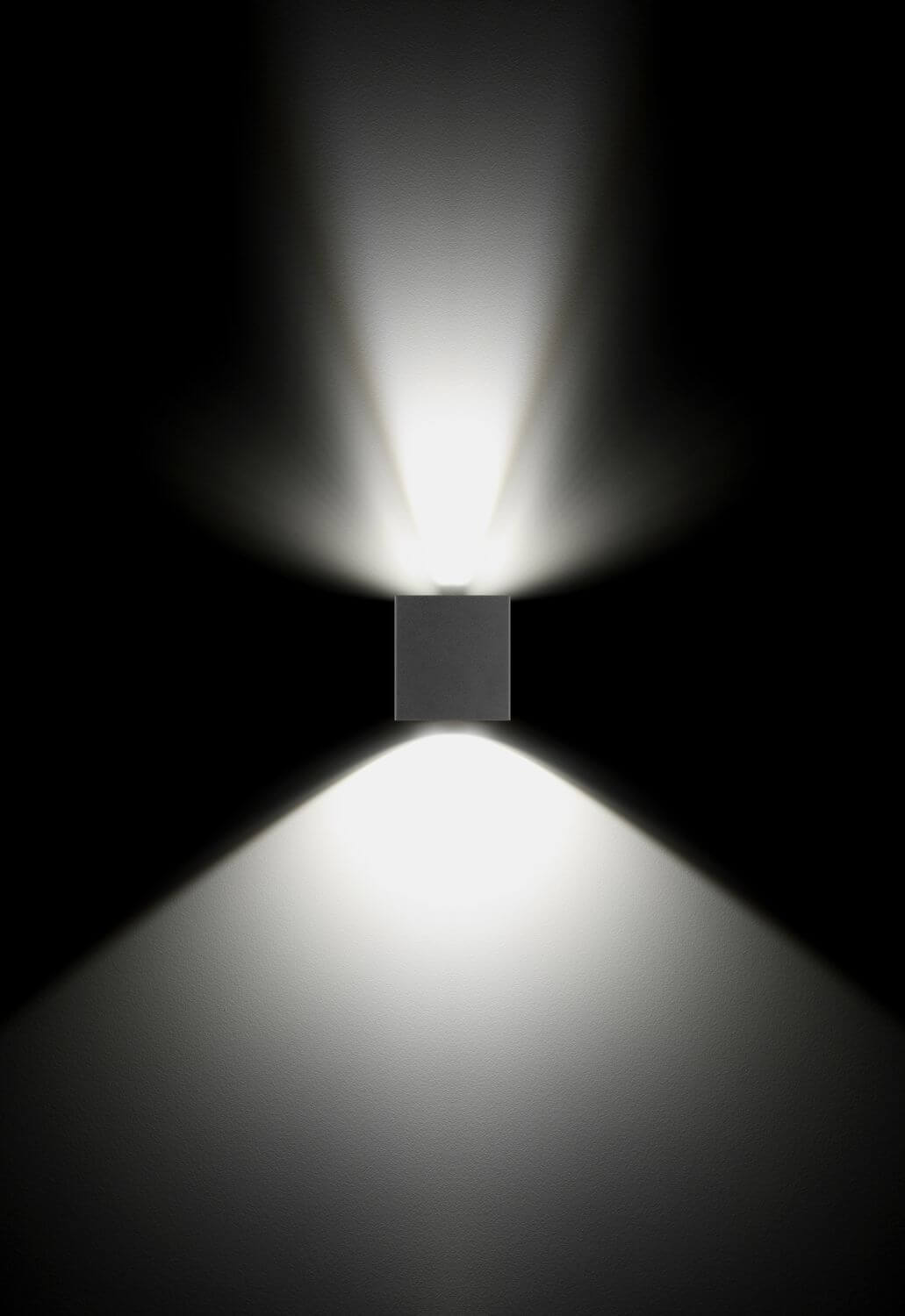 Effet de lumière sur fond noir : double faisceau haut et bas d'une applique murale