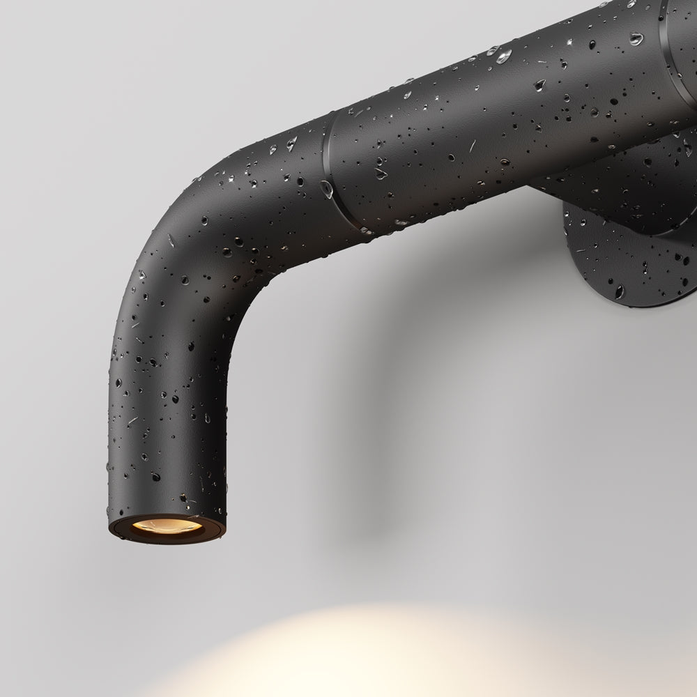 Gros plan du tube noir mat couvert de gouttes d'eau, usage extérieur