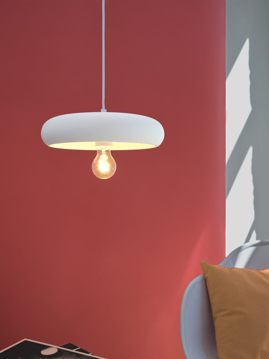 Détail du dessous de la suspension avec ampoule allumée, lumière chaude.