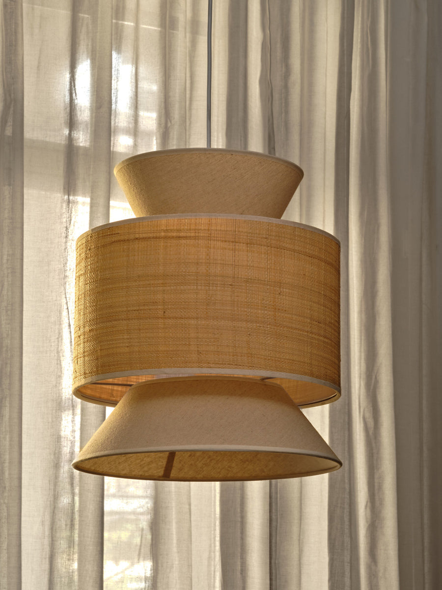 Gros plan sur la texture tissée de l'abat-jour beige devant des rideaux.