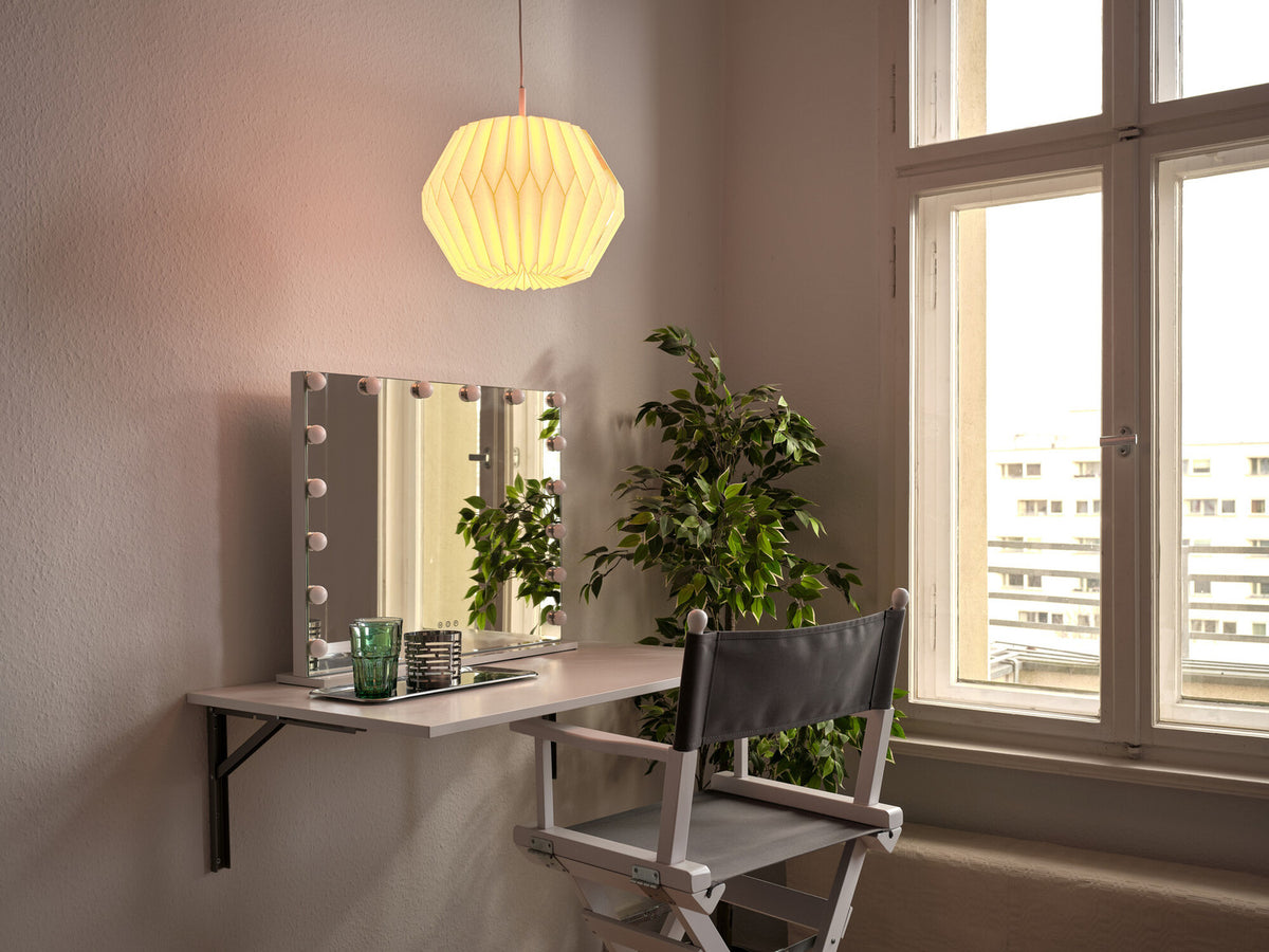 Mise en ambiance chaleureuse au-dessus d'un bureau avec miroir et plante.
