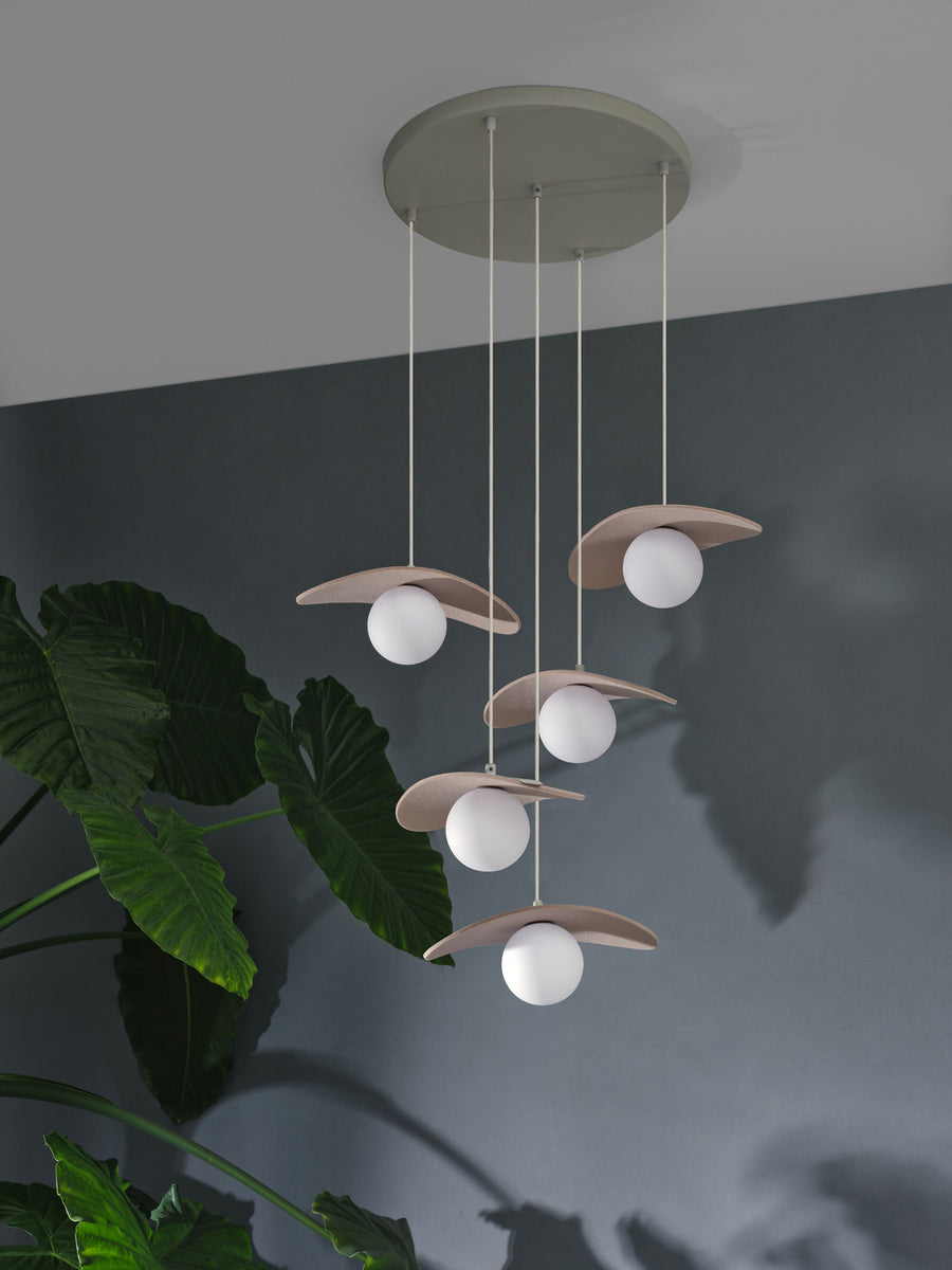 Vue en plongée de la suspension installée, ombres portées sur mur gris.
