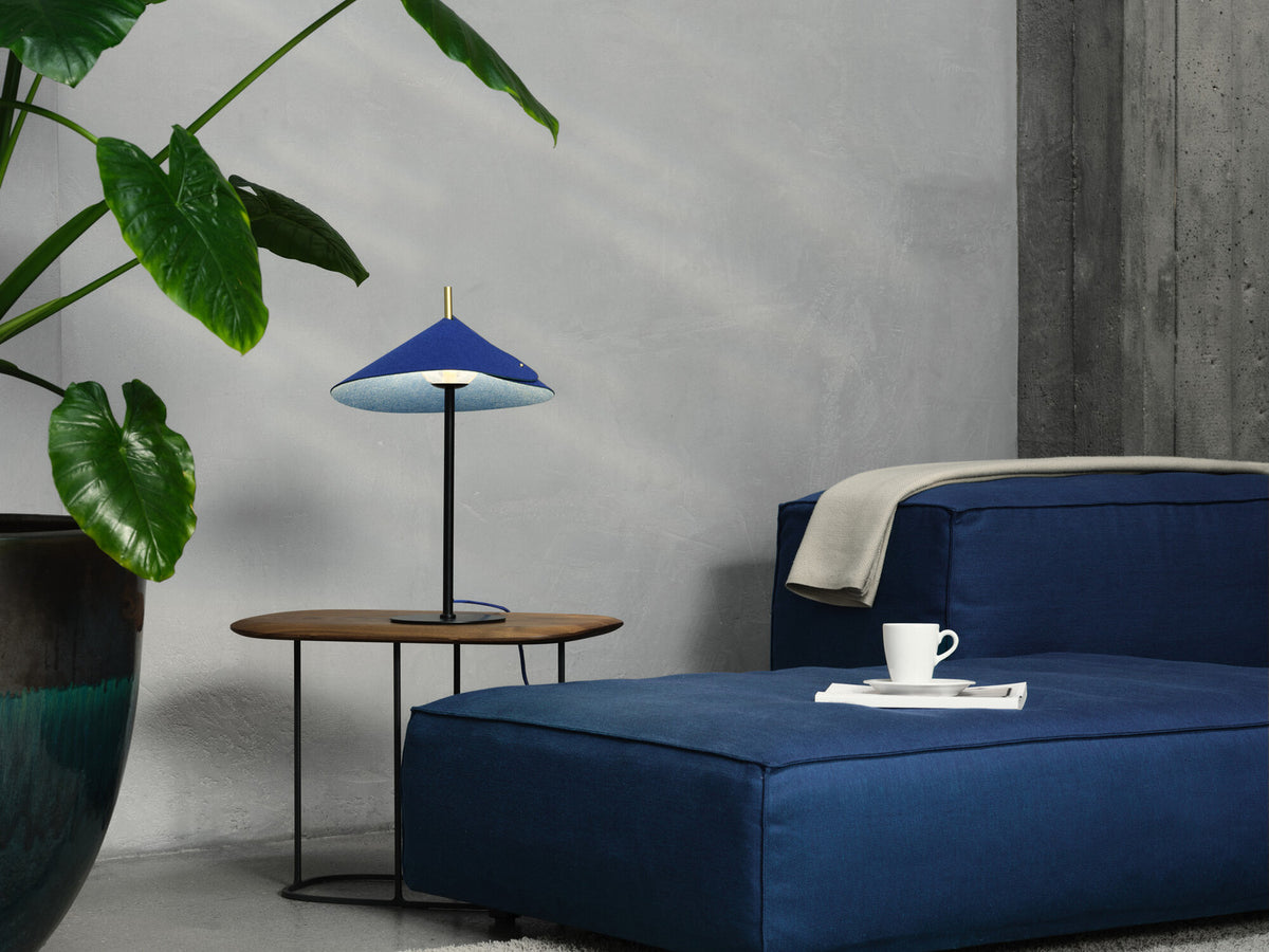 Mise en ambiance dans un salon, lampe bleue posée sur une table basse en bois.