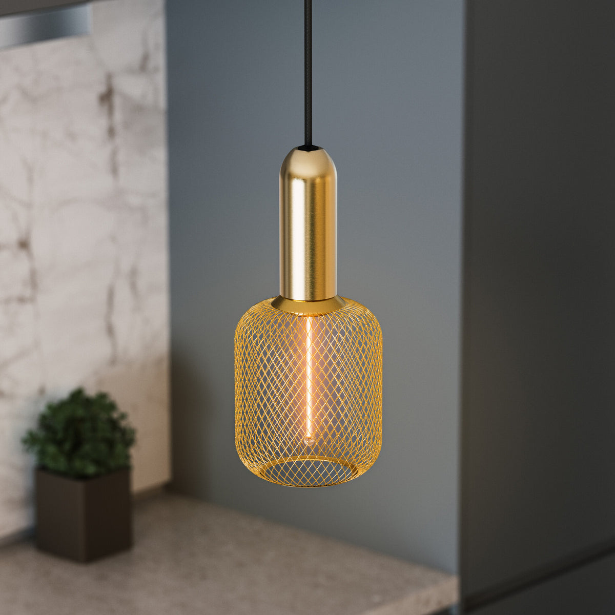 Mise en ambiance sur fond gris et marbre, suspension dorée avec abat-jour grillagé cylindrique.