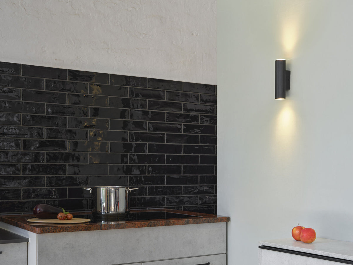 Applique noire installée dans une cuisine, éclairant mur et crédence noire
