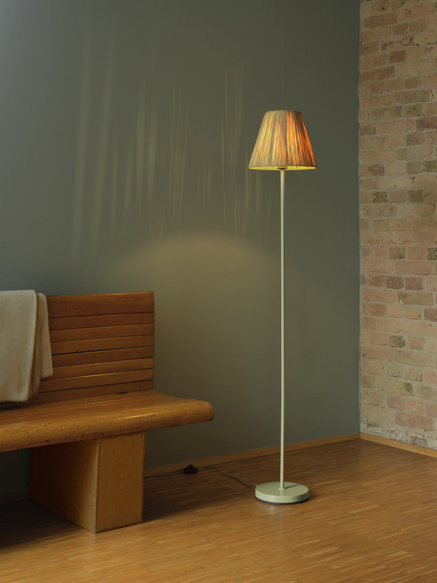 Ambiance intérieure avec lampadaire allumé près banc, ombres douces sur mur