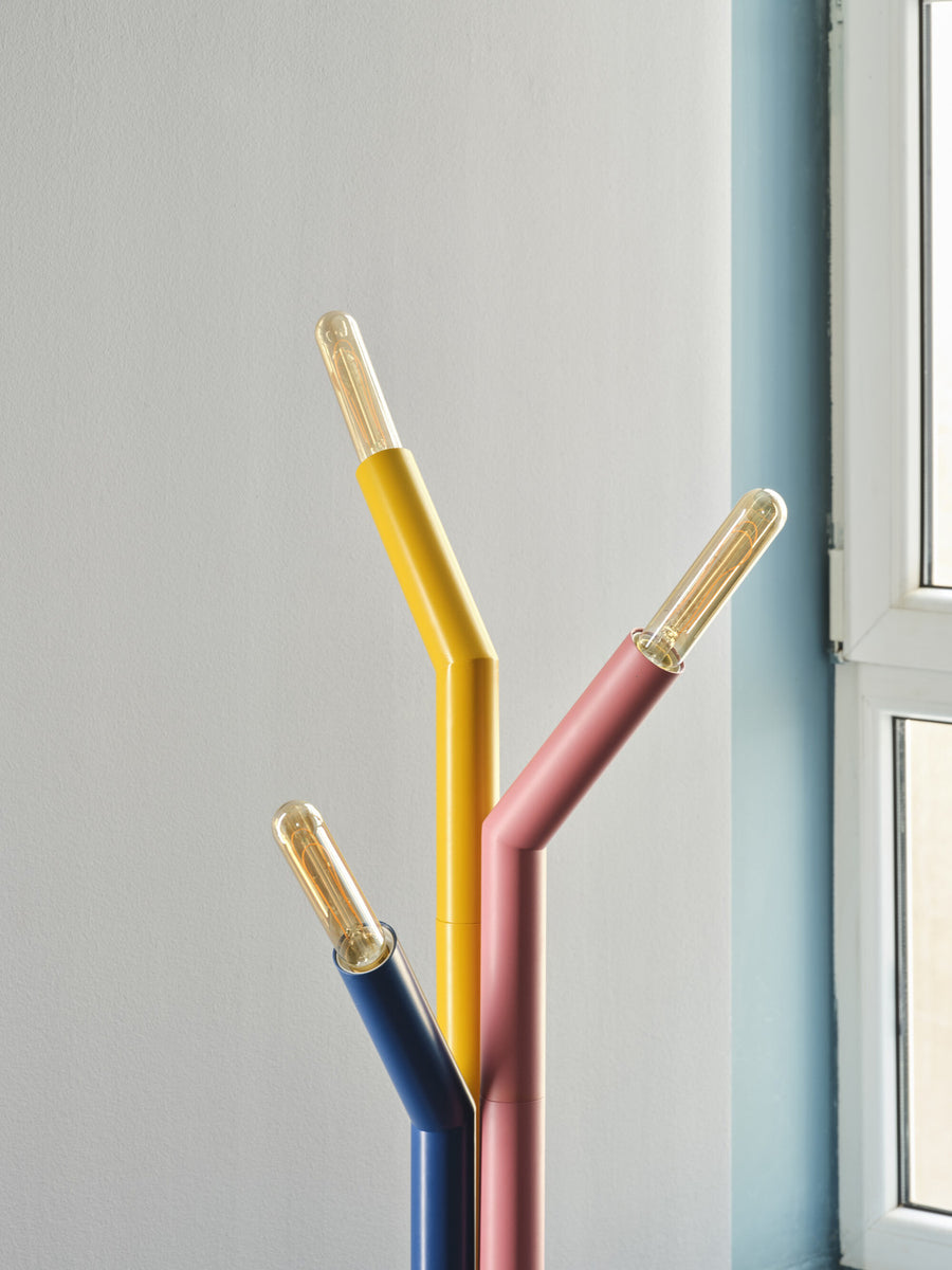 Détail des trois tiges colorées et des ampoules transparentes allumées du lampadaire.