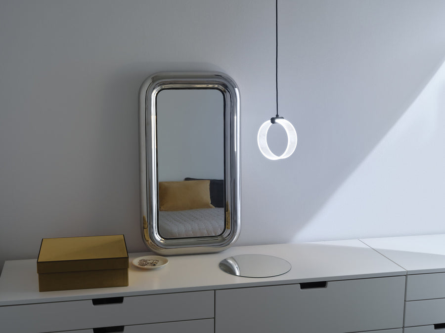 Scène d'intérieur avec miroir, meuble blanc et suspension anneau allumée