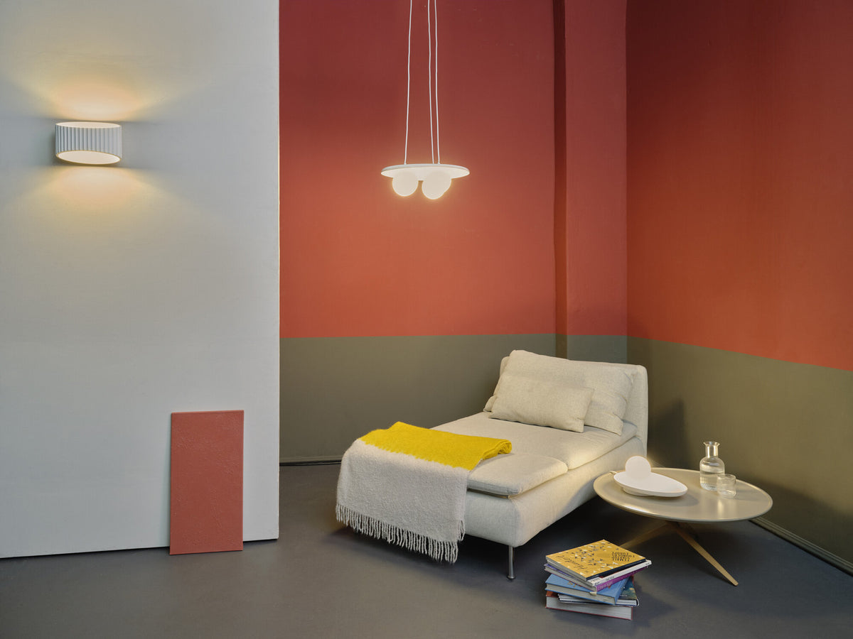 Mise en ambiance dans un salon, suspension allumée au-dessus d'une méridienne.