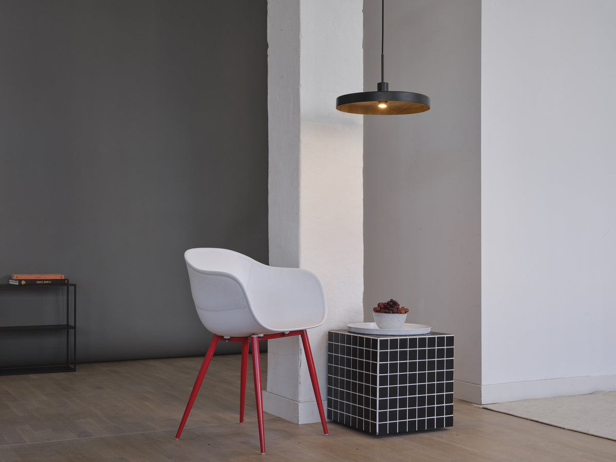 Mise en ambiance avec suspension au-dessus d'une chaise blanche et d'un cube.