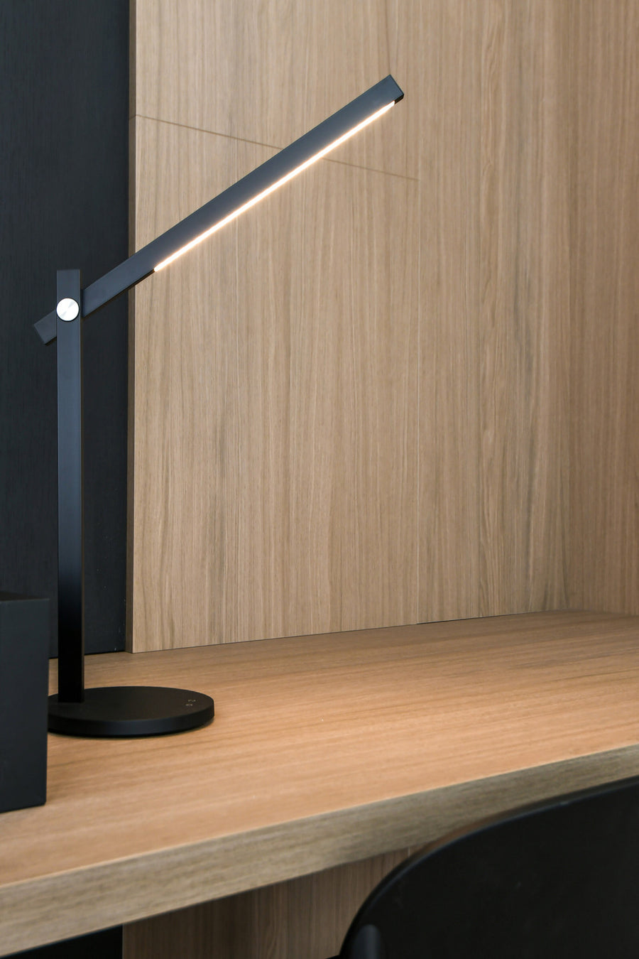 Vue rapprochée sur bureau en bois clair, la lumière éclaire le plan de travail