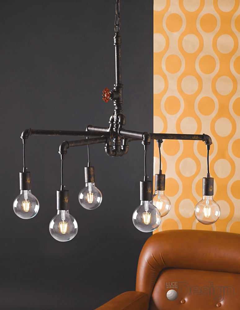 Mise en ambiance avec la suspension industrielle devant un mur orange et un canapé marron.