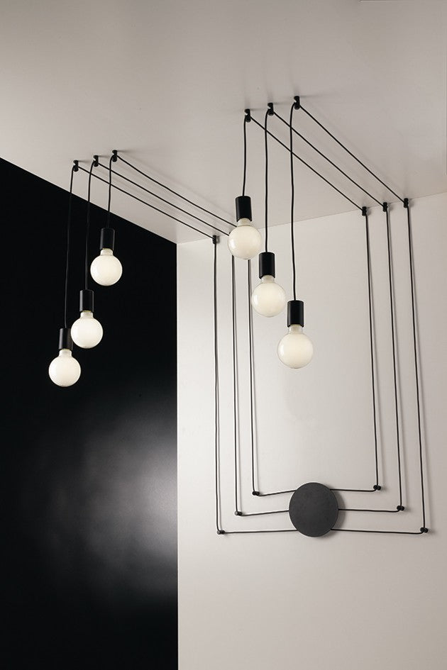 Mise en ambiance du plafonnier noir avec ampoules rondes allumées sur fond contrasté.
