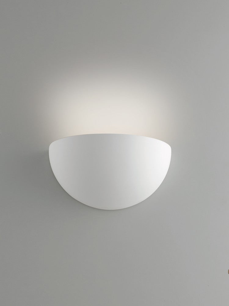 Mise en ambiance sur mur gris, lumière chaude diffusée en éventail