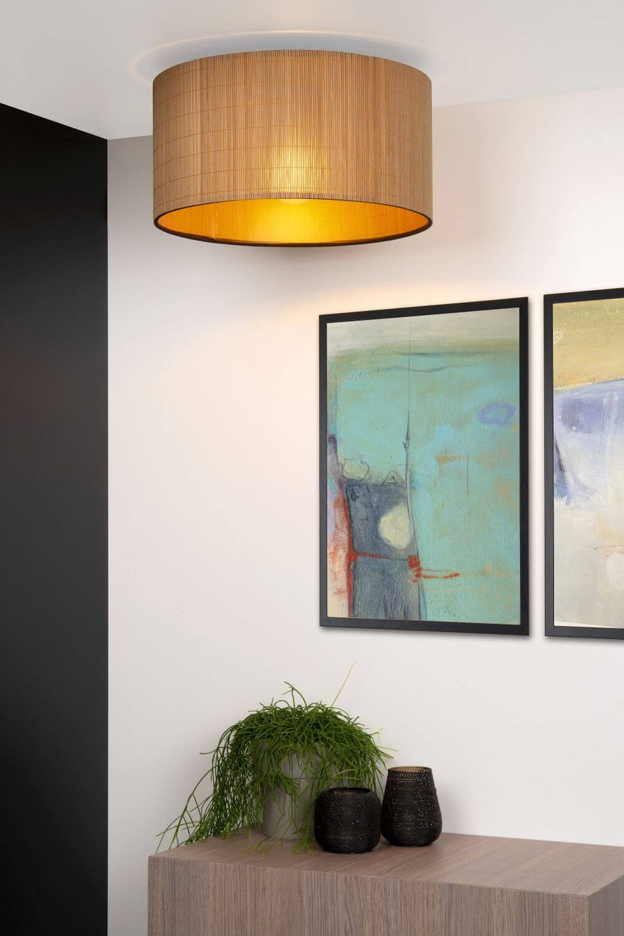 Vue rapprochée du plafonnier en rotin allumé, intégré à un décor mural.