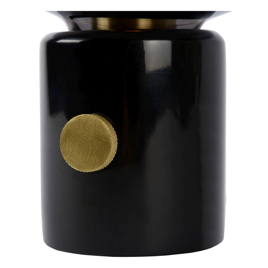 Détail du socle laqué noir et du bouton doré moleté de réglage.