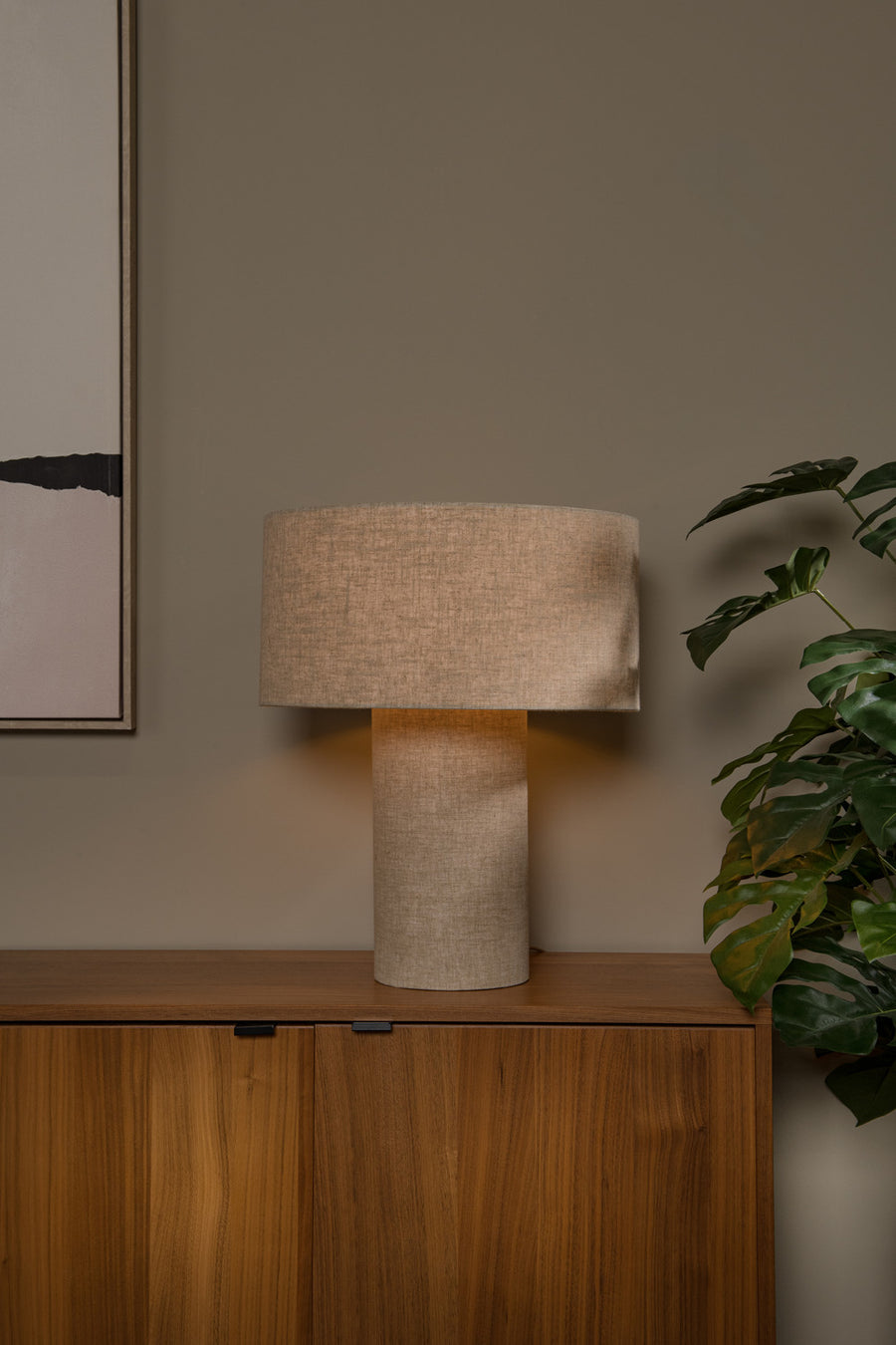 Vue de face du luminaire allumé sur un buffet en bois foncé