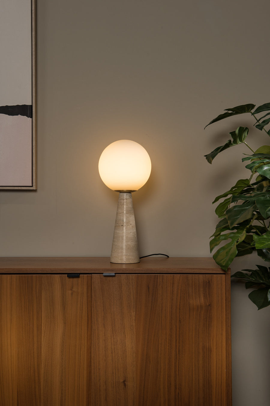 Vue rapprochée du globe opale diffusant une lumière chaude sur le buffet