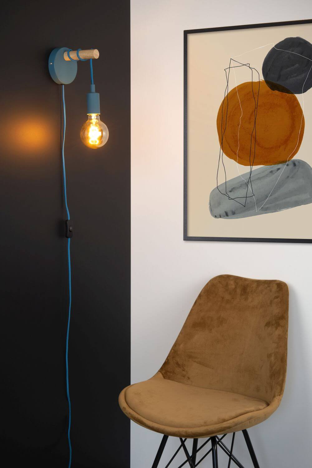 Vue rapprochée de l'applique bleue et bois clair, ampoule allumée sur mur sombre.