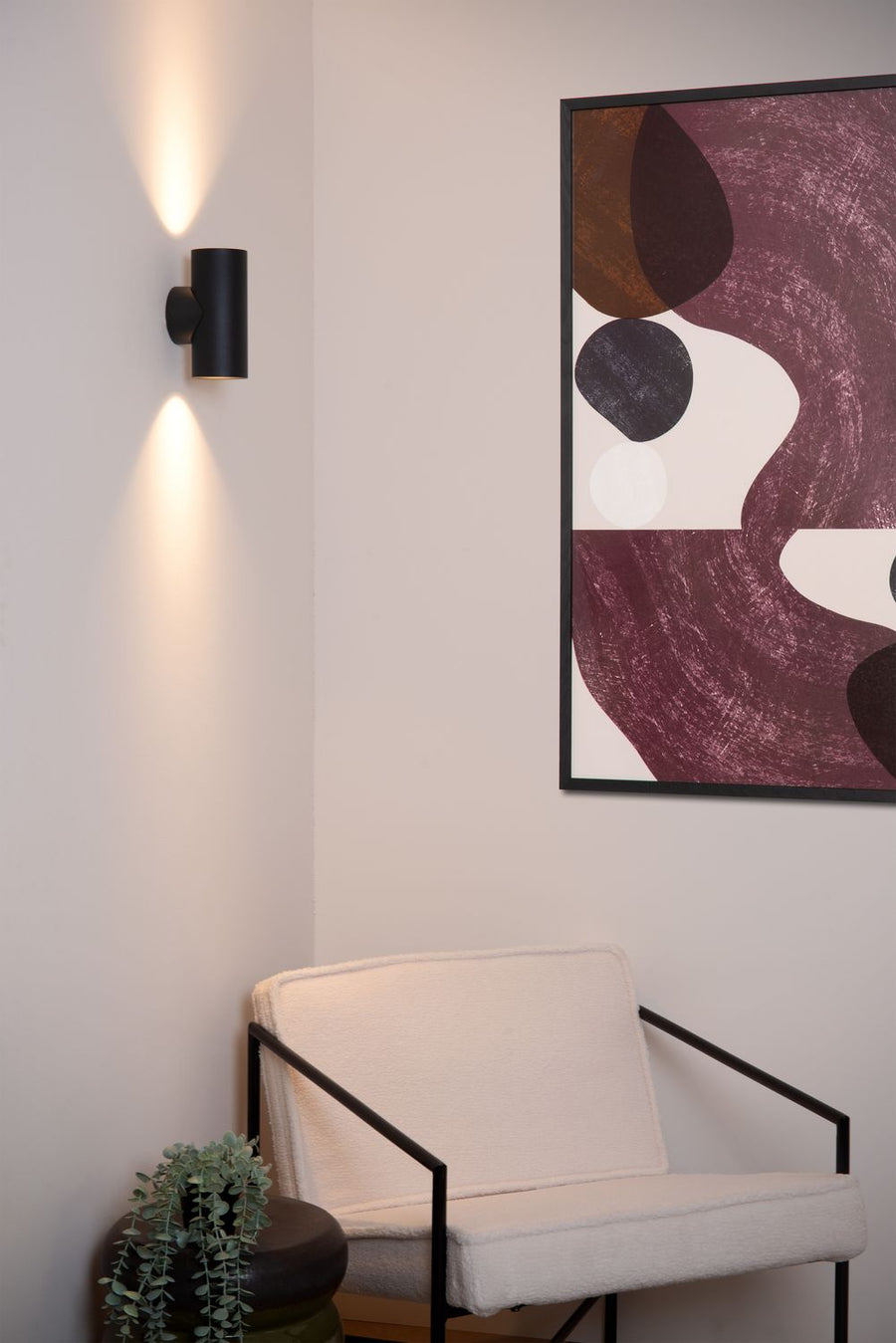 Vue rapprochée de l'applique murale noire diffusant un halo vers le haut et le bas