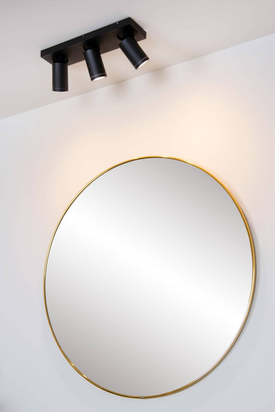 Vue en contre-plongée du plafonnier, spots braqués vers le miroir doré