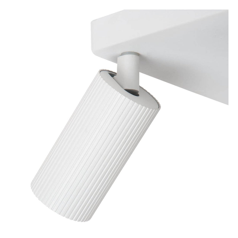 Détail de l'articulation et de la finition rainurée d'un spot cylindrique blanc, non allumé.
