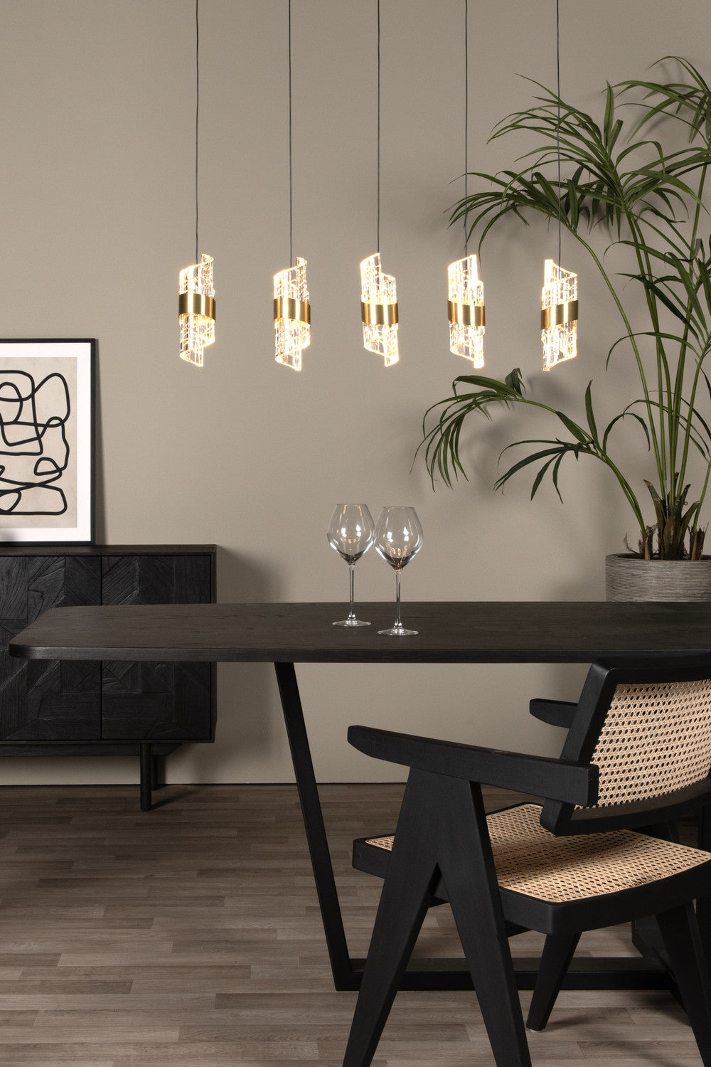 Vue rapprochée de la suspension dorée au-dessus de la table et des verres.