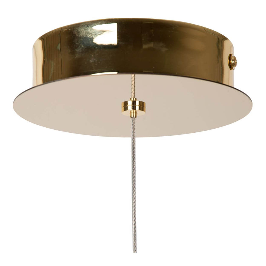 Détail de la rosace dorée fixée au plafond avec câble tressé et bague de réglage.