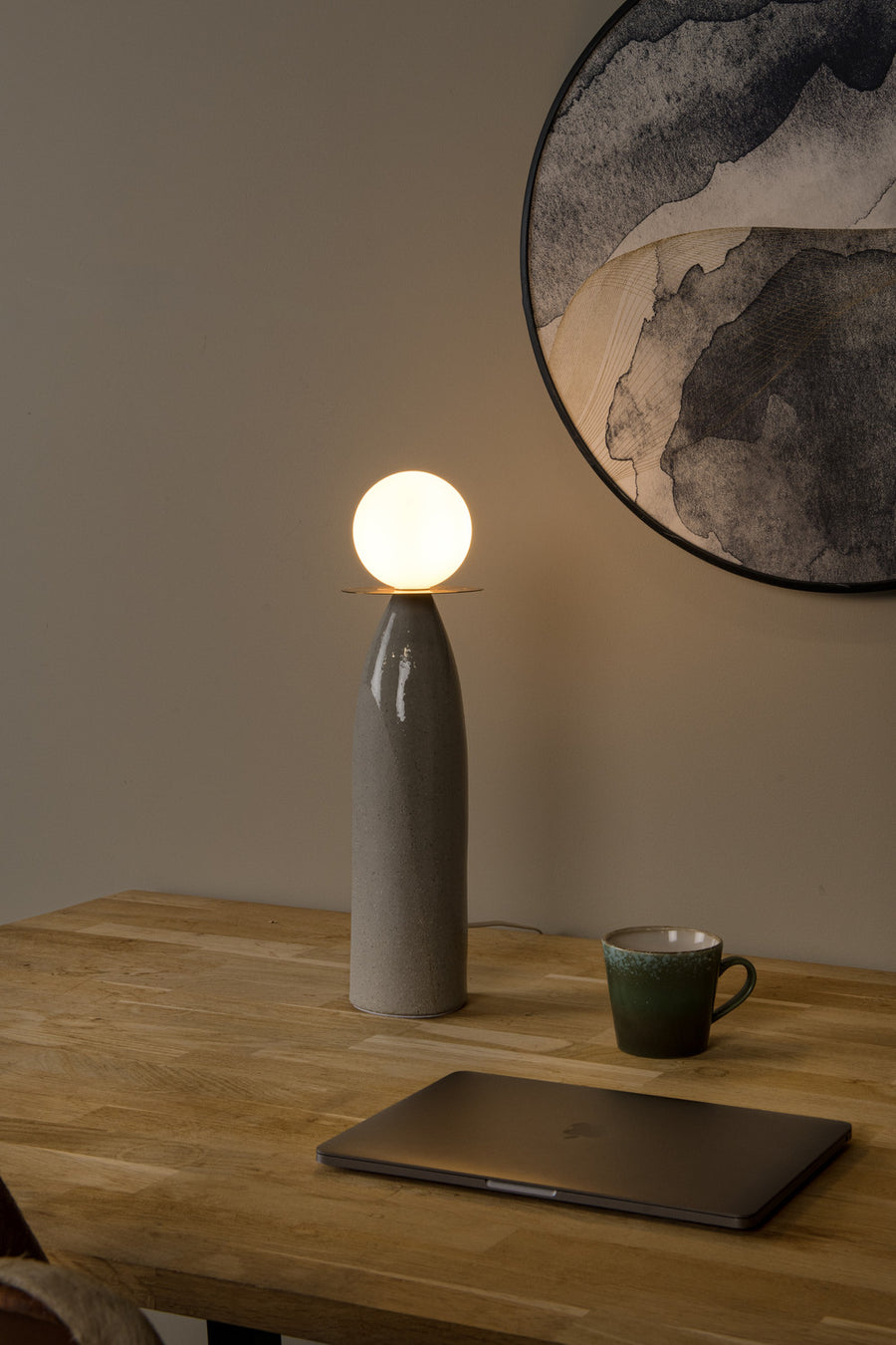 Vue rapprochée de la lampe allumée sur une table en bois, cadre arrondi au mur
