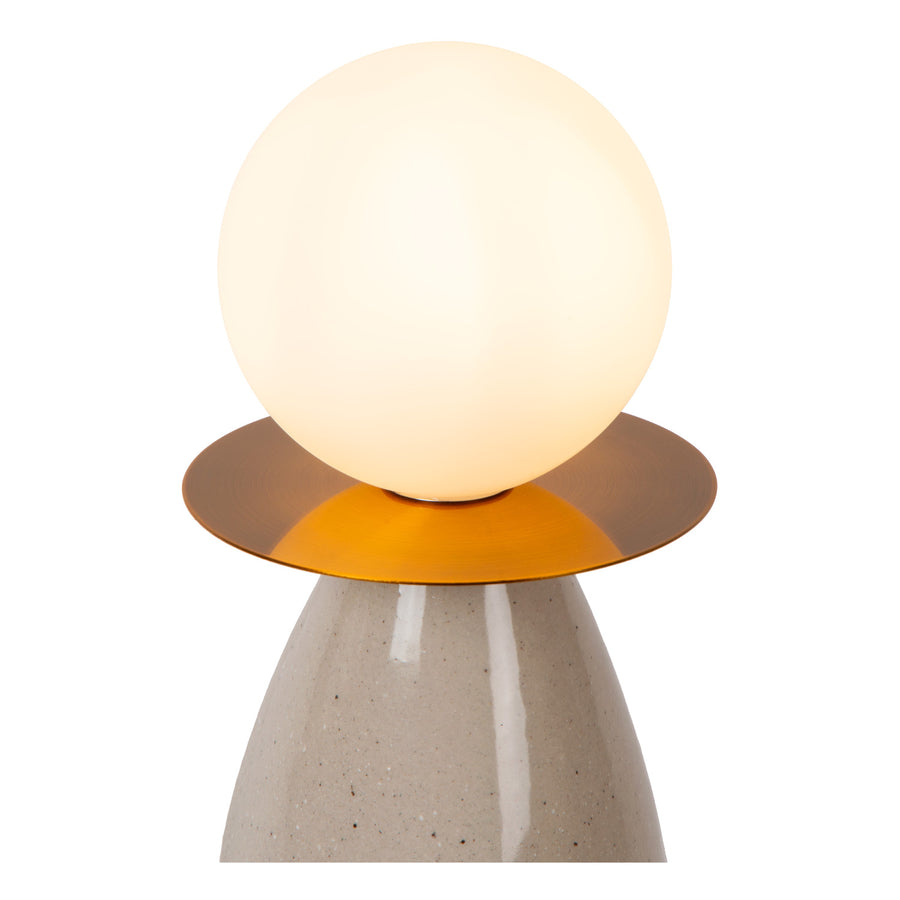 Détail du globe en verre opalin posé sur une coupelle métallique dorée, base céramique
