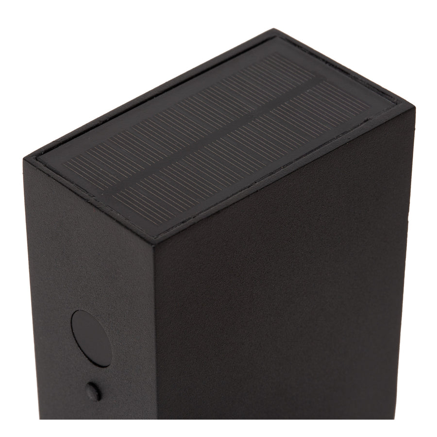 Détail du dessus montrant le panneau solaire strié intégré au boîtier noir.