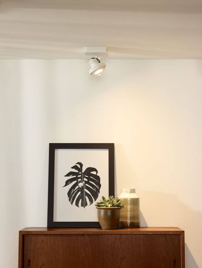 Mise en ambiance du plafonnier blanc allumé au-dessus d'un meuble en bois