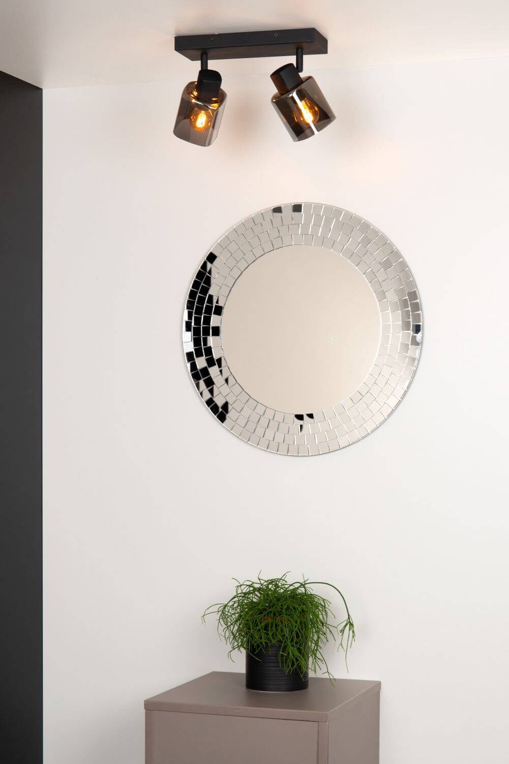 Vue en contre-plongée du plafonnier noir allumé, deux diffuseurs fumés orientables devant un miroir.