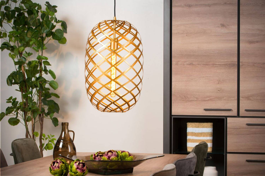Vue rapprochée de la suspension dorée dans une salle à manger avec meuble en bois.