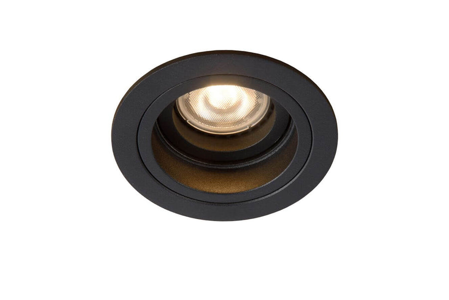 Détail du spot rond noir encastré, réflecteur strié et ampoule chaude allumée