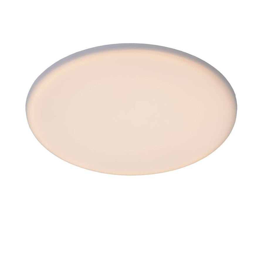 Vue de biais du luminaire rond blanc éclairé sur fond neutre uni