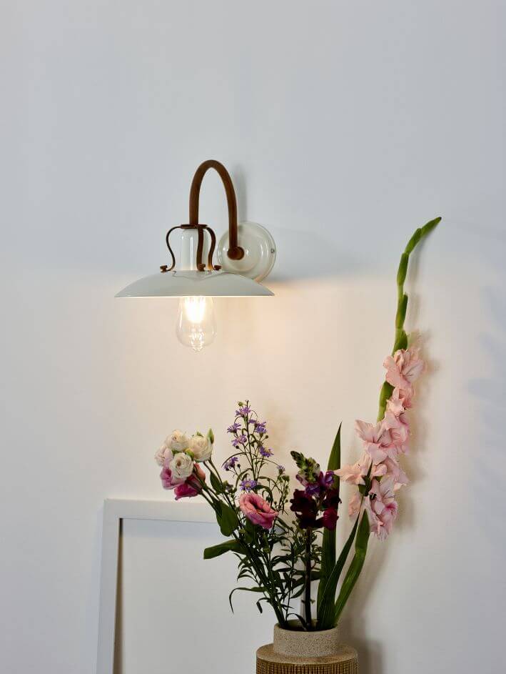 Applique murale blanche et rouille allumée sur fond blanc avec fleurs séchées