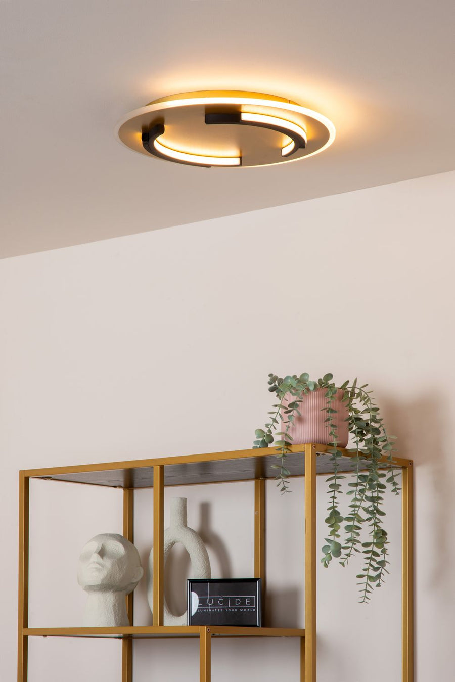 Vue rapprochée du luminaire rond fixé au plafond, halo lumineux chaud