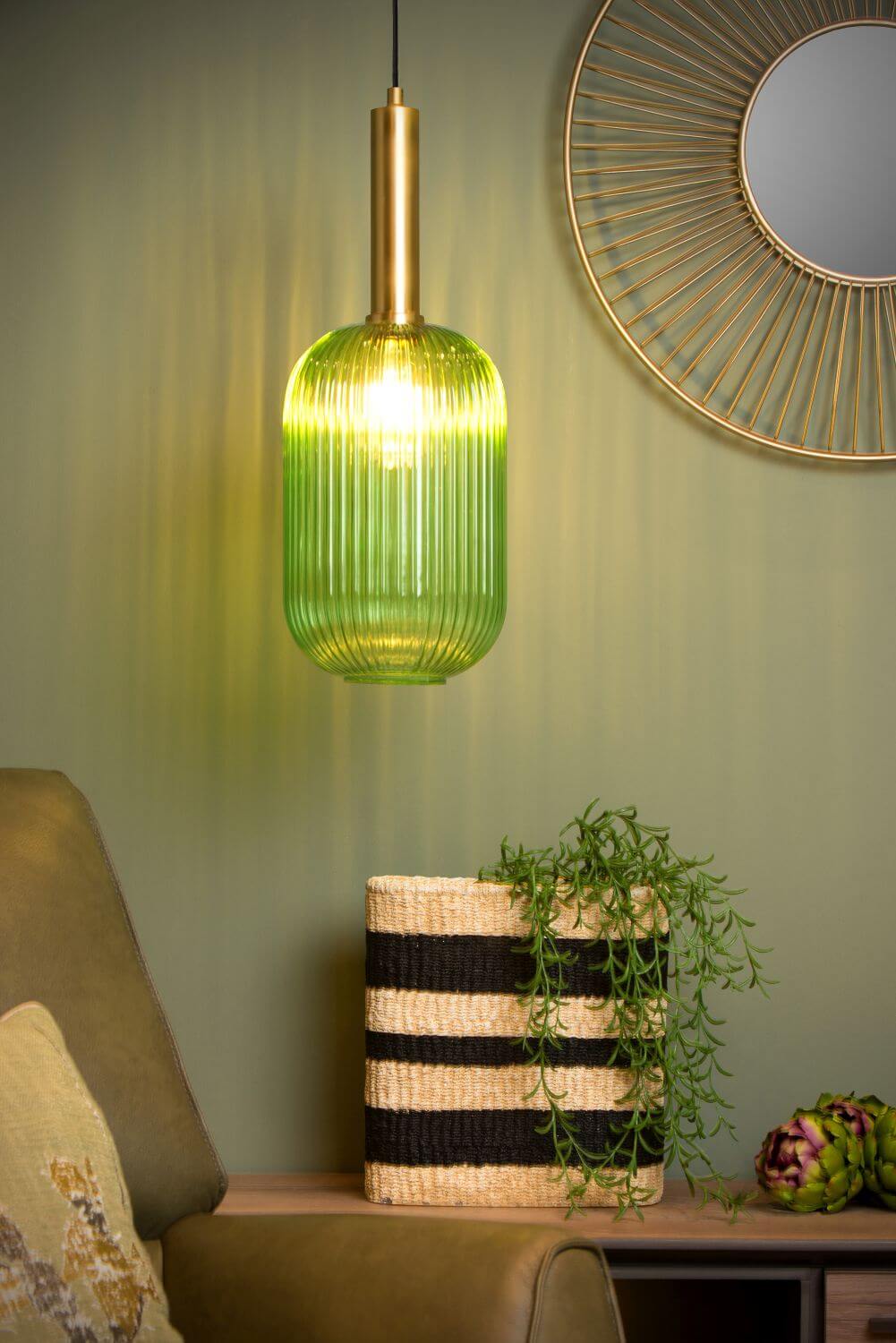 Gros plan sur la suspension verte allumée, verre strié, miroir doré et panier.