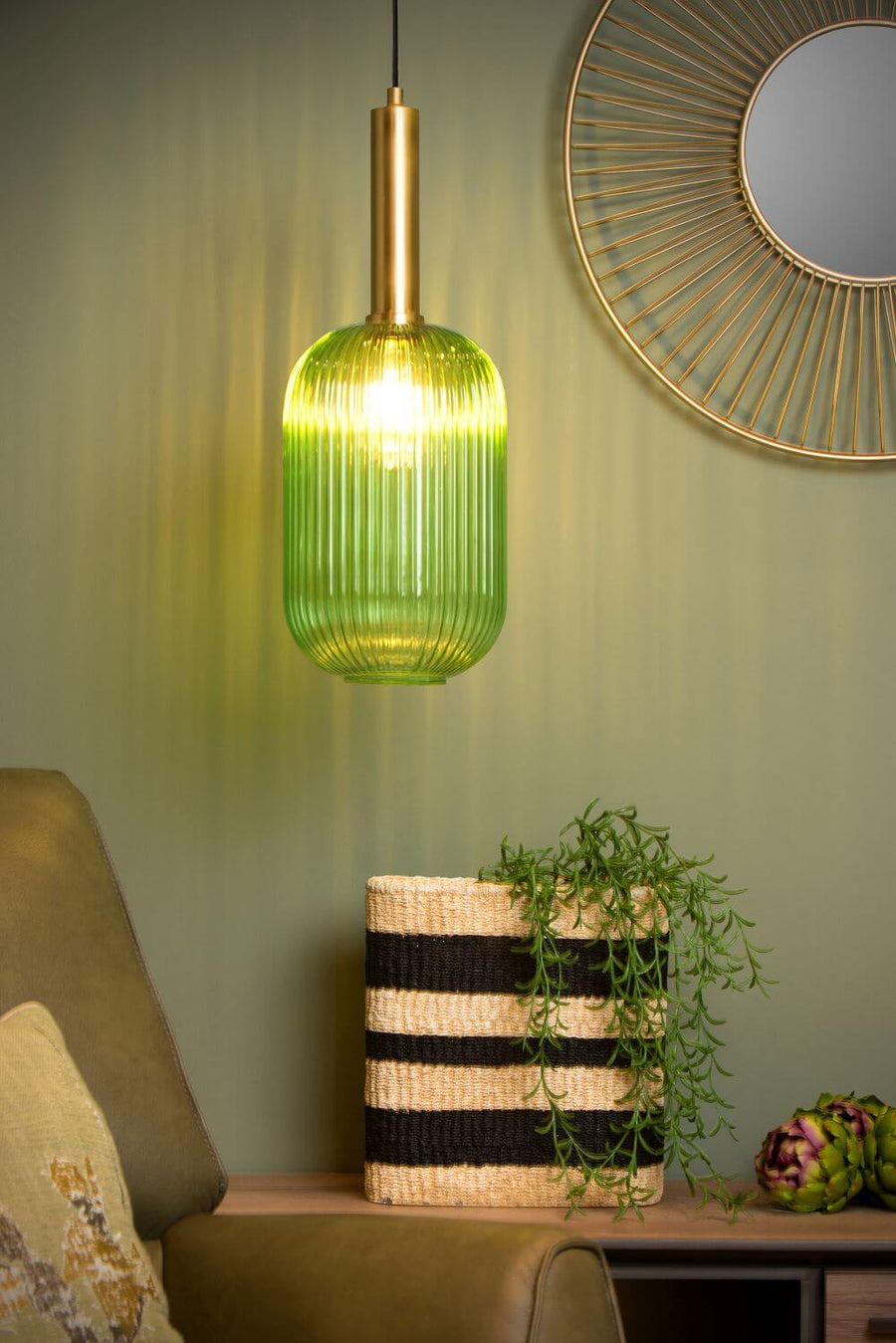 Gros plan sur la suspension verte allumée, verre strié, miroir doré et panier.
