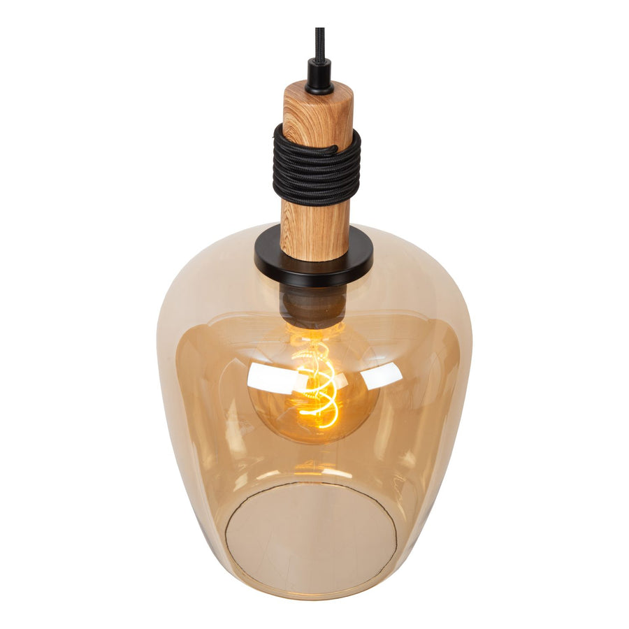 Vue rapprochée en plongée sur le diffuseur en verre ambré et l'ampoule Edison allumée.