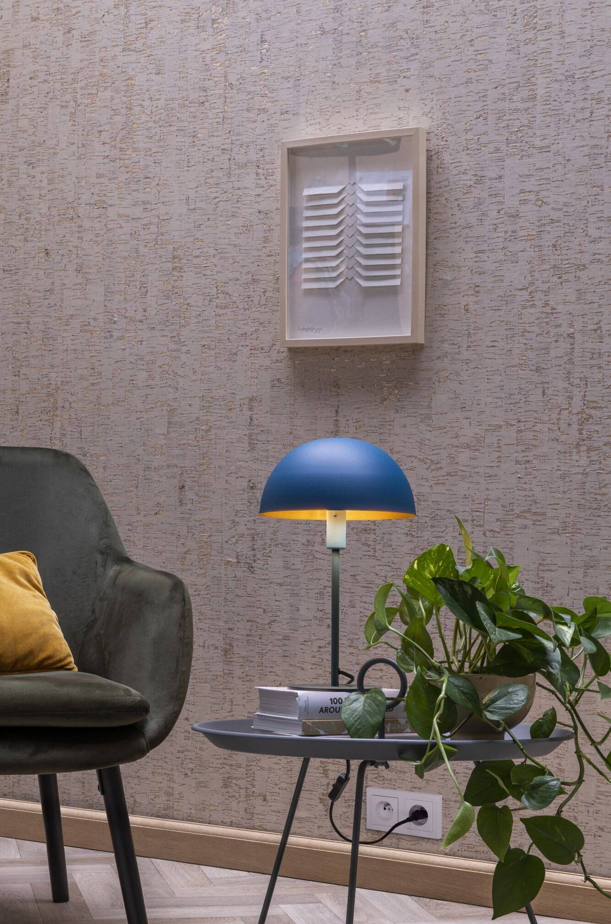 Vue rapprochée de la lampe bleue sur la table, intérieur doré et plante verte