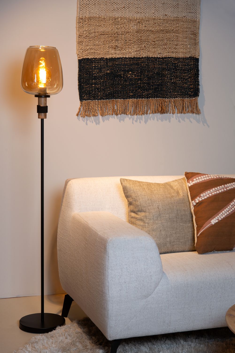 Vue d'ambiance montrant le lampadaire noir et verre ambré dans un salon