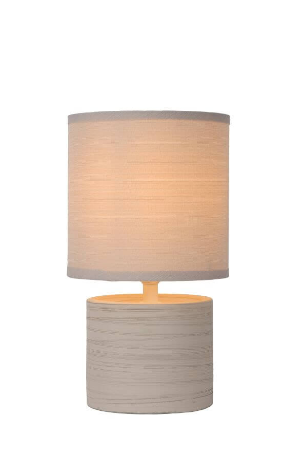 Photo produit de face, lampe allumée avec abat-jour textile beige et base cylindrique grise.